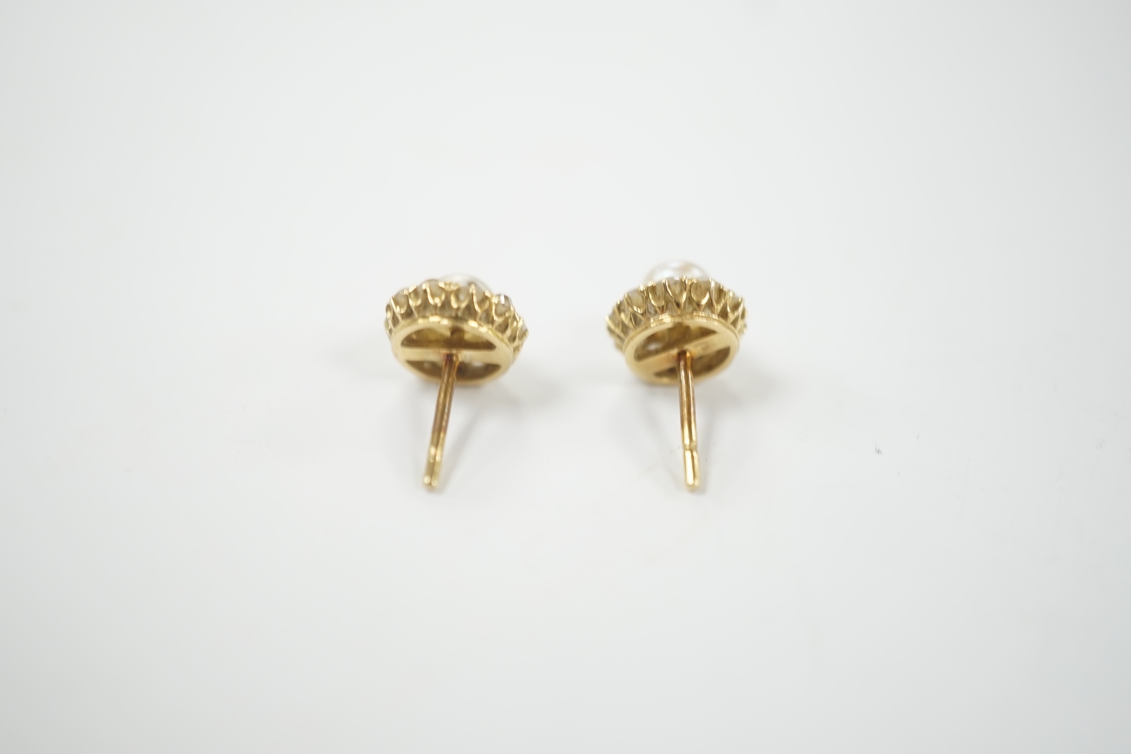 A pair of yellow metal (stamped 18), cultured pearl and diamond cluster set flower head ear studs, diameter 9mm, gross weight 2.9 grams.